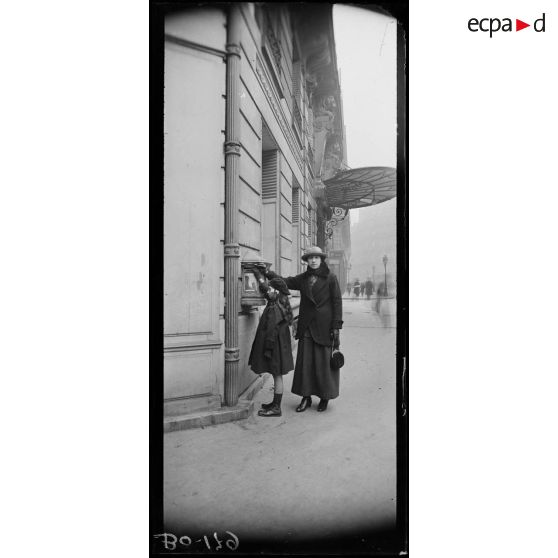 Enfant mettant une lettre à la poste. [légende d’origine]