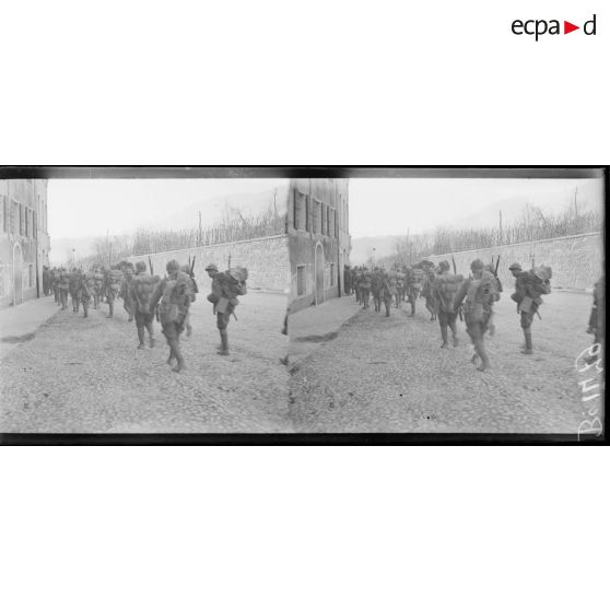 Possagno. Infanterie italienne revenant des lignes traversant le village bombardé. [légende d'origine]