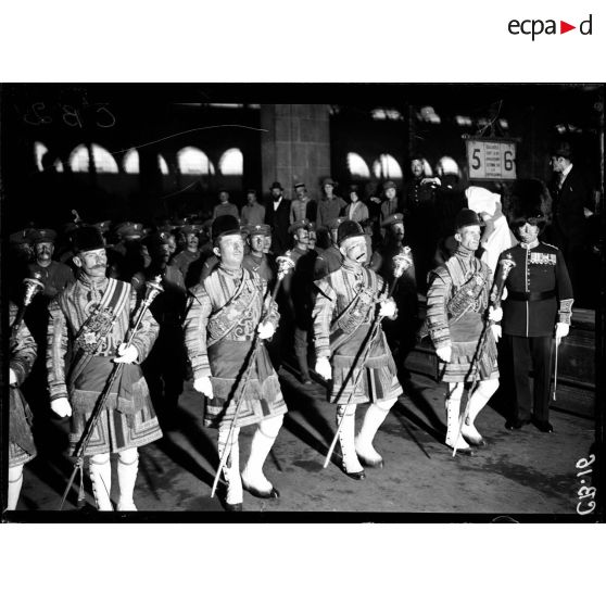 Le défilé des musiciens de la Garde royale anglaise sur les quais de la gare du Nord. [légende d'origine]