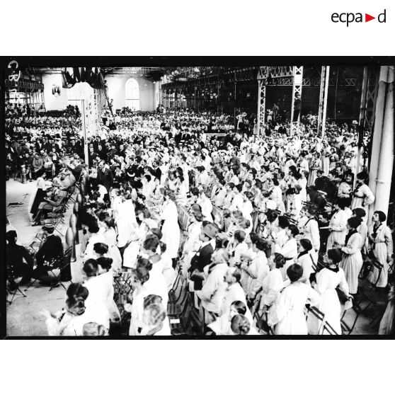 Les ouvrières écoutent les hymnes nationaux. [légende d'origine]