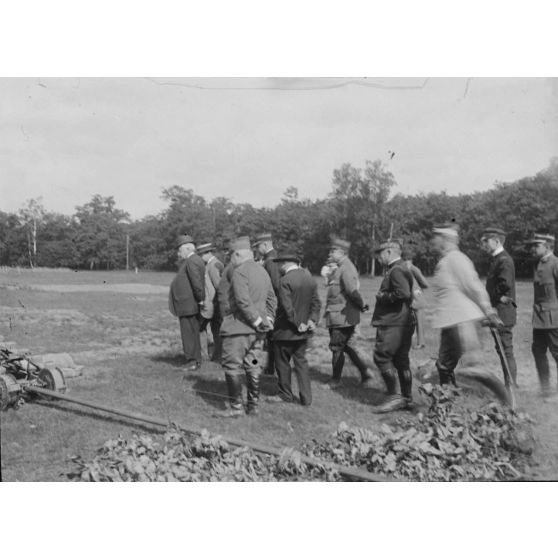 [Groupe d'autorités civiles et militaires avançant vers une chenille en essai sur un terrain, s.d.]