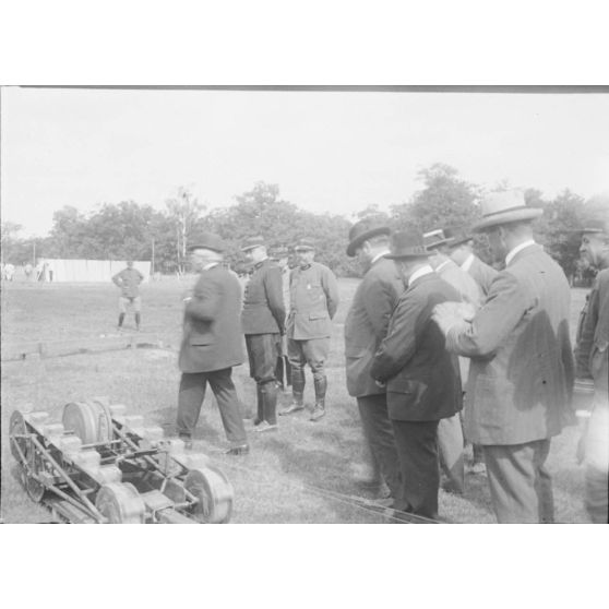 [Groupe d'autorité observant le passage d'une chenille en expérimentation, s.d.]