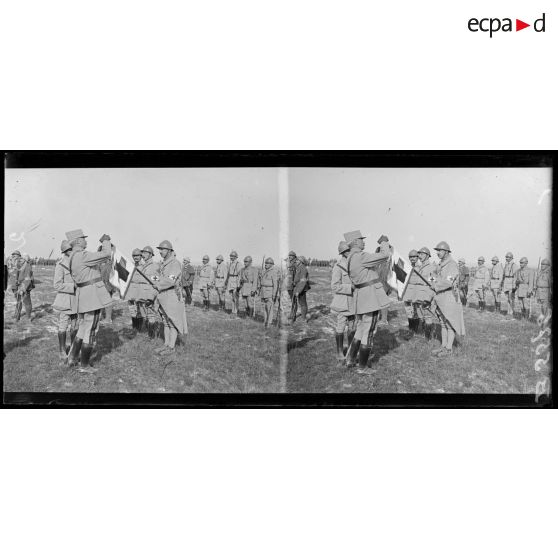 Le général Passaga décore de la Croix de Guerre le fanion du groupe de brancardiers divisionnaire de la 42e DI. [légende d'origine]