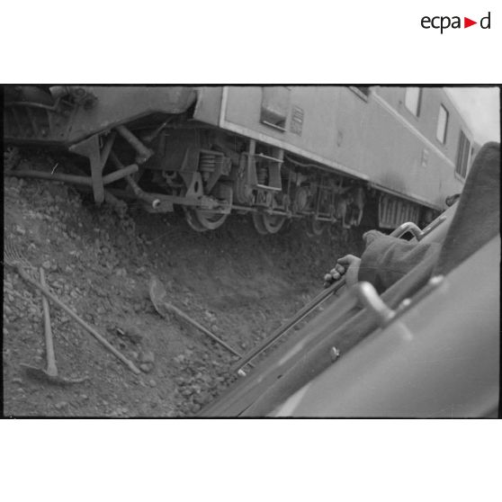 Vue du train qui a déraillé sur le bas-côté de la voie ferrée. [légende d'origine]