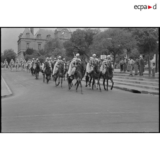 Défilés des spahis à cheval. En tête, les officiers ouvrent la marche. [légende d'origine]