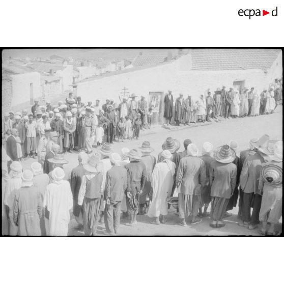 La population regarde passer les autorités civiles et militaires. [légende d'origine]