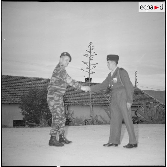 Le colonel Bigeard serre la main d'un soldat. [légende d'origine]