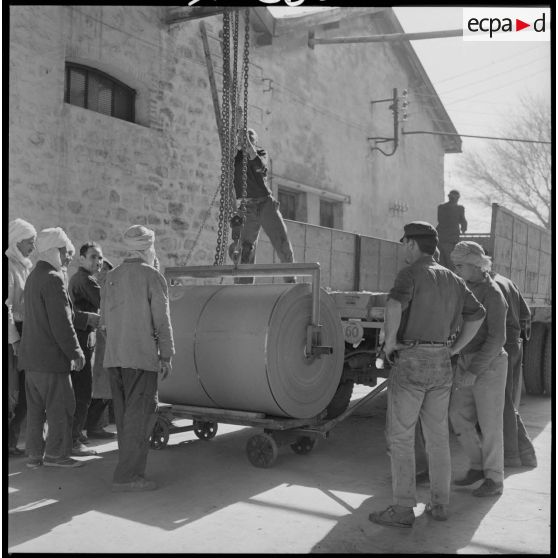 [Papeterie d'Aïn-el-Hadjar. Chargement d'un compresseur sur un camion.]