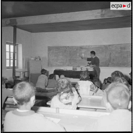 Dans la salle de classe, un professeur explique la leçon. [légende d'origine]
