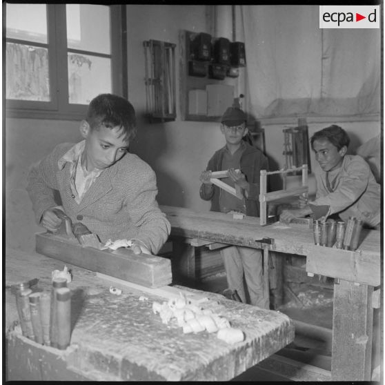 Apprentissage professionnel. Jeunes garçons à l'ouvrage dans un atelier dédié au travail du bois. [légende d'origine]