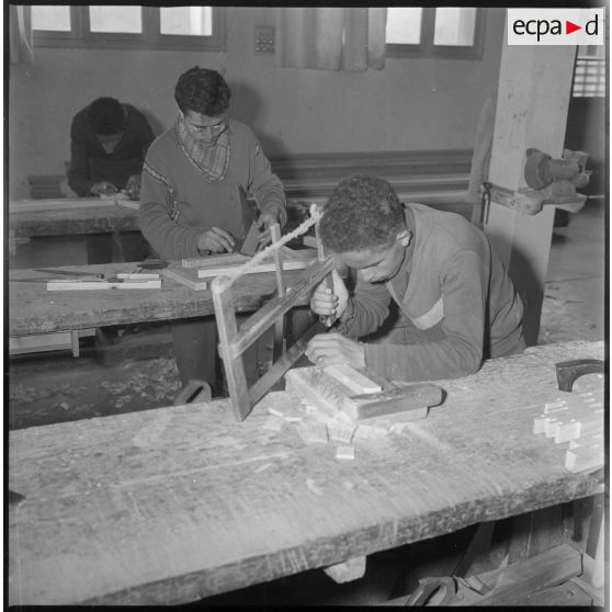 Apprentissage professionnel. Jeunes garçons à l'ouvrage dans un atelier dédié au travail du bois. [légende d'origine]