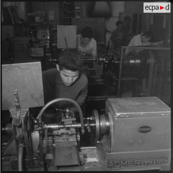 Apprentissage professionnel. Élèves derrière un poste d'ajustage ou de filetage. [légende d'origine]