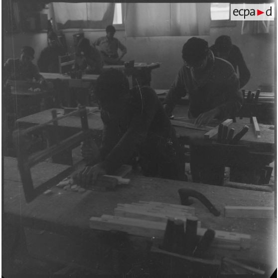 Apprentissage professionnel. Jeunes garçons à l'ouvrage dans un atelier dédié au travail du bois. [légende d'origine]