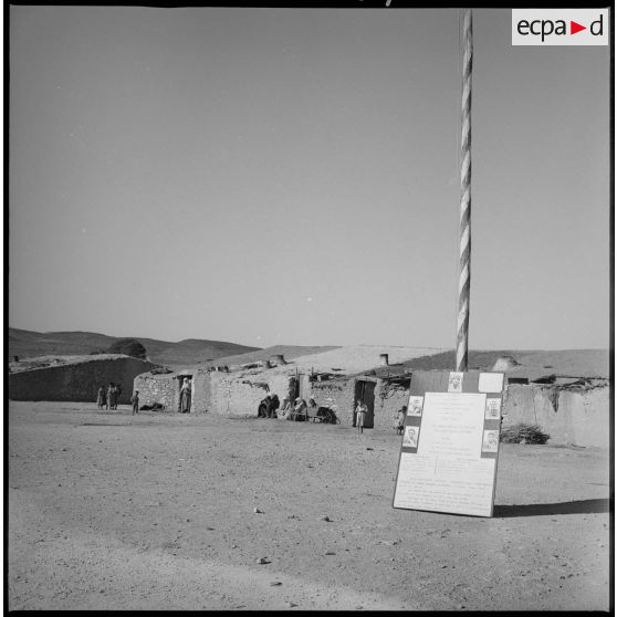 Panneau d'information servant à l'action psychologique du secteur implanté dans un village. [légende d'origine]