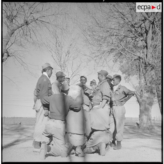 Plusieurs membres du commando Cobra sont rassemblés autour d'un globe terrestre et écoutent attentivement les observations qui leurs sont faites. [légende d'origine]