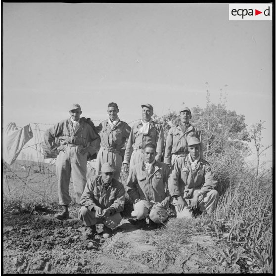 Portrait de groupe de plusieurs membres du commando Cobra. En arrière-plan, des barbelés. [légende d'origine]