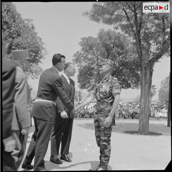 Visite du Délégué général du gouvernement en Algérie Paul Delouvrier à Saïda. Le lieutenant Georges Grillot, chef du commando de chasse "Georges" serre la main d'un élu local. [légende d'origine]