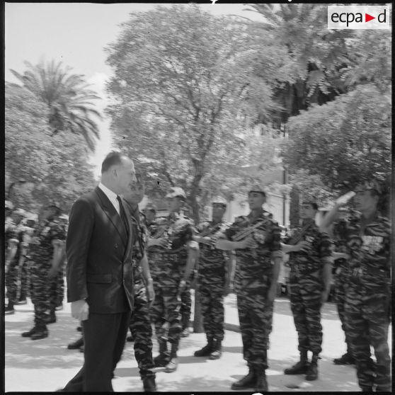 Le Délégué général du gouvernement en Algérie Paul Delouvrier accompagné du lieutenant Georges Grillot, chef du commando "Georges", passe en revue les commandos de chasse du secteur de Saïda. [légende d'origine]