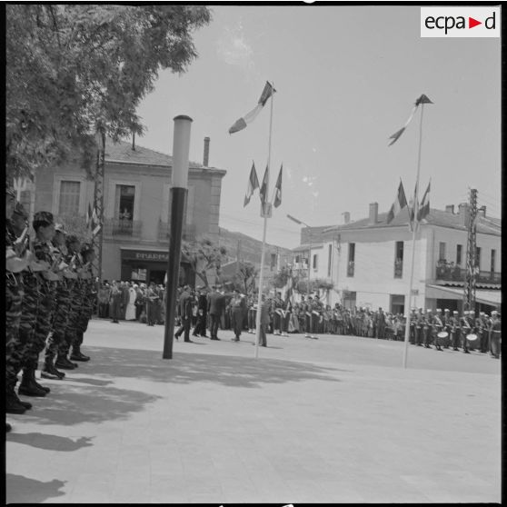 Vue de la place principale de Saïda. Sur la droite, des membres des commandos de chasse du secteur présentent les armes. Au centre, au second plan, les autorités civiles et militaires discutent. [légende d'origine]