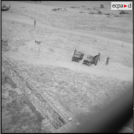 Vue aérienne du poste de Tircine. Des soldats et des jeeps sont visibles au sol. [légende d'origine]