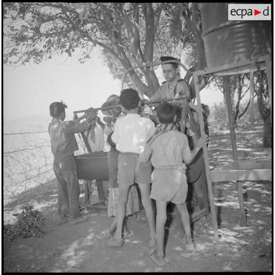 Au Camp des chasseurs du 8e RIM, des enfants se lavent les mains. [légende d'origine]