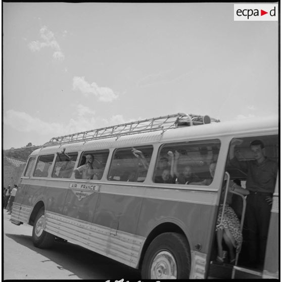 En ville, vue d'un bus Air France venu récupérer des enfants pour les emmener au Camp des chasseurs du 8e RIM. Plusieurs enfants sont déjà montés à l'intérieur. [légende d'origine]