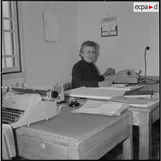 [Papeterie d'Aïn-el-Hadjar. Portrait d'une employée assise derrière un bureau.]