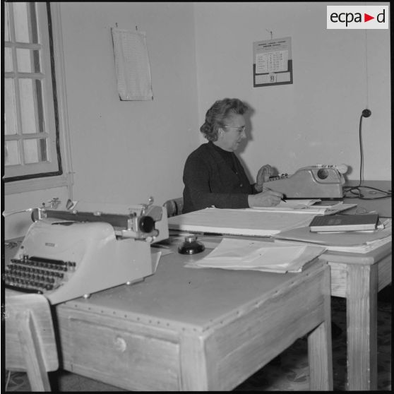 [Papeterie d'Aïn-el-Hadjar. Portrait d'une employée assise derrière un bureau.]