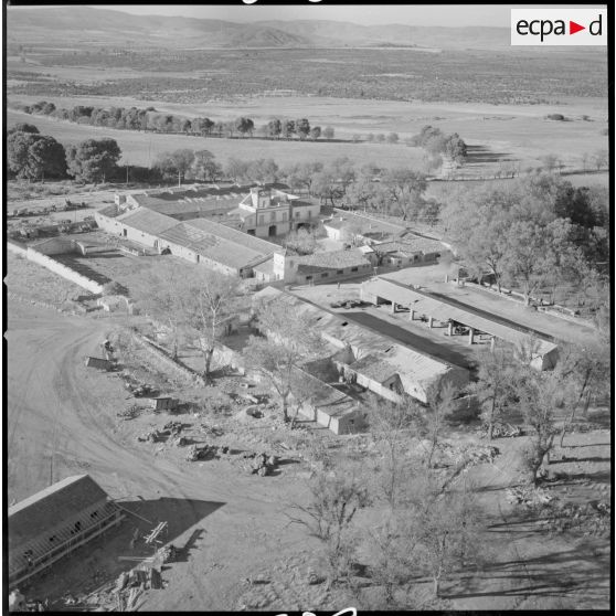 [Vue aérienne de la ferme d'Aïn Zerga. En bas à gauche de la photographie, on peut voir un ouvrier sur une charpente en construction.]