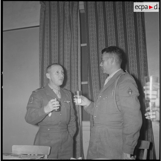 [PC du 2/8e RIM à Tissemiran-Haut. Soldats buvant un apéritif au cours de la remise de certificat de bonne conduite du chef de bataillon Dastillung, à gauche, au capitaine Audric, à droite.]