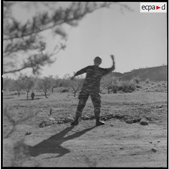 [Entraînement de parachutistes dans un verger du Vieux Saïda. Soldat lançant une grenade à main factice.]