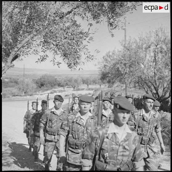 [Entraînement des parachutistes dans le Vieux Saïda. Soldats marchant en ordre serré sur une piste.]