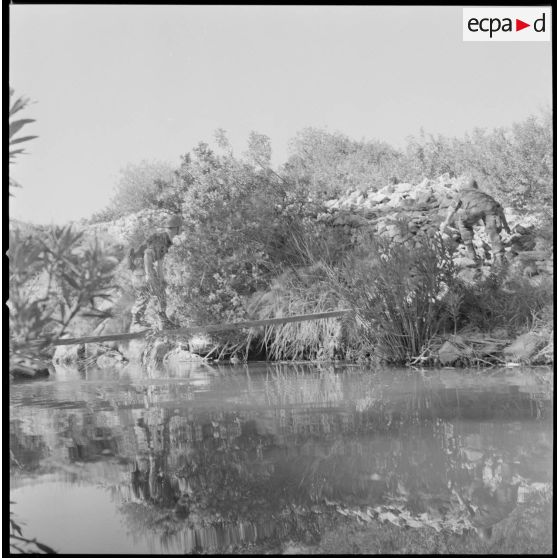 [Entraînement de parachutistes dans le Vieux Saïda. Soldat franchissant un cours d'eau.]