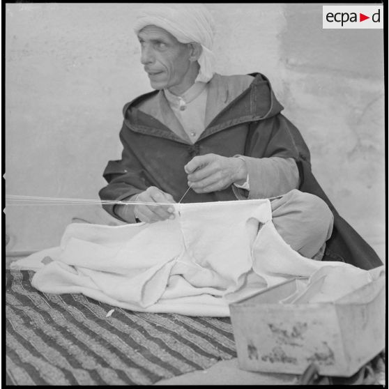 [Artisan effectuant un travail manuel de tissage traditionnel.]