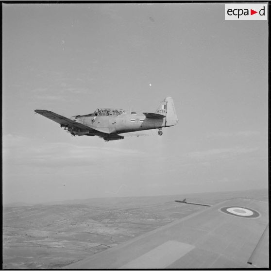 [Avion North American T-6 portant l'insigne de la 20/72e escadrille d'aviation légère d'appui (EALA) en vol de reconnaissance.]