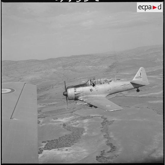 [Avion North American T-6 portant l'insigne de la 20/72e escadrille d'aviation légère d'appui (EALA) en vol de reconnaissance.]