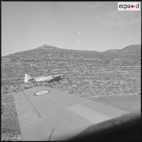 [Avion North American T-6 portant l'insigne de la 14/72e escadrille d'aviation légère d'appui (EALA) en vol de reconnaissance.]