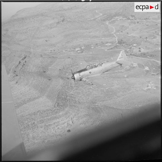 [Avion North American T-6 portant l'insigne de la 20/72e escadrille d'aviation légère d'appui (EALA) en vol de reconnaissance.]