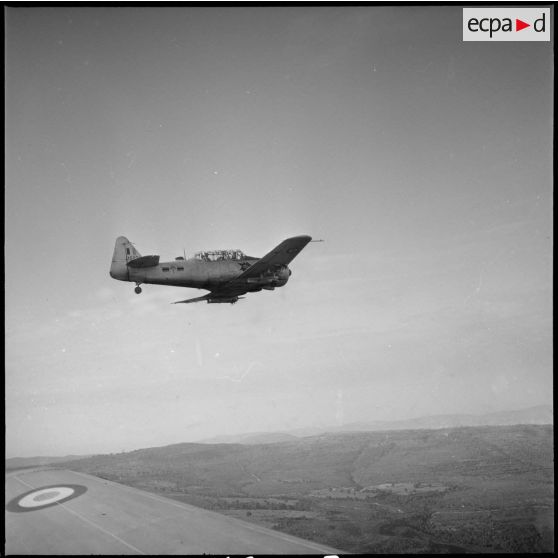 [Avion North American T-6 portant l'insigne de la 14/72e escadrille d'aviation légère d'appui (EALA) en vol de reconnaissance.]