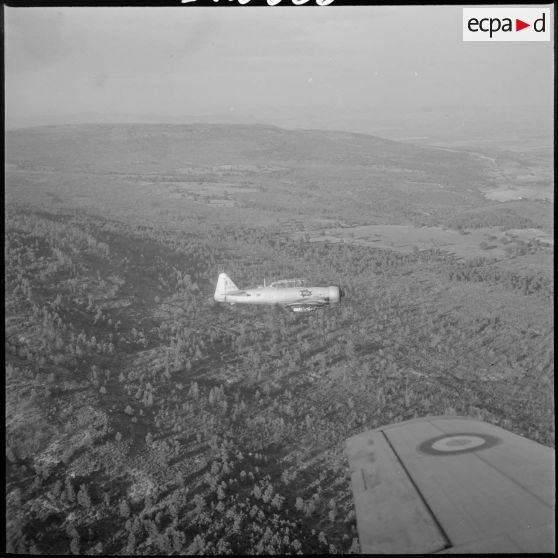 [Avion North American T-6 portant l'insigne de la 14/72e escadrille d'aviation légère d'appui (EALA) en vol de reconnaissance.]