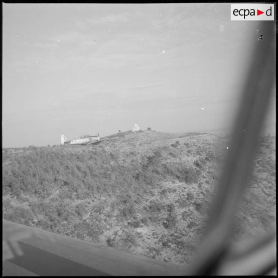 [Avion North American T-6 portant l'insigne de la 14/72e escadrille d'aviation légère d'appui (EALA) en vol de reconnaissance.]