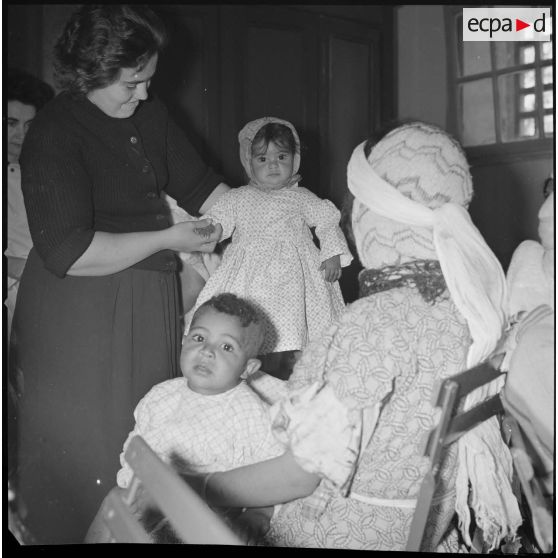 [Jeune enfant algérien vêtue des habits cousus lors d'un atelier d'apprentissage à Aïn el Hadjar.]