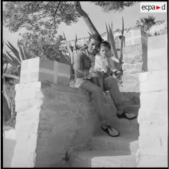 [Portrait du chauffeur du colonel du 8e régiment d'infanterie motorisée (8e RIM) avec sa fille à Aïn el Hadjar.]