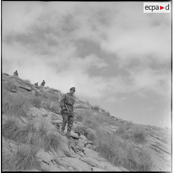 [Soldat du commando Cobra progressant dans les monts des Ksour avec son pistolet-mitrailleur.]