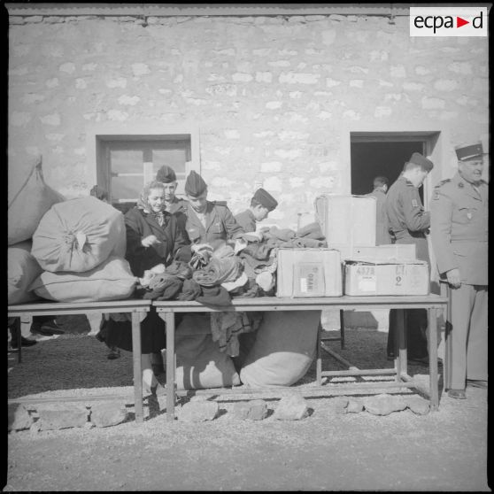 [Poste de Tamesna, région de Saïda. Femme et soldats triant des vêtements donnés à l'occasion d'une action caritative initiée par des Luxembourgeois.]