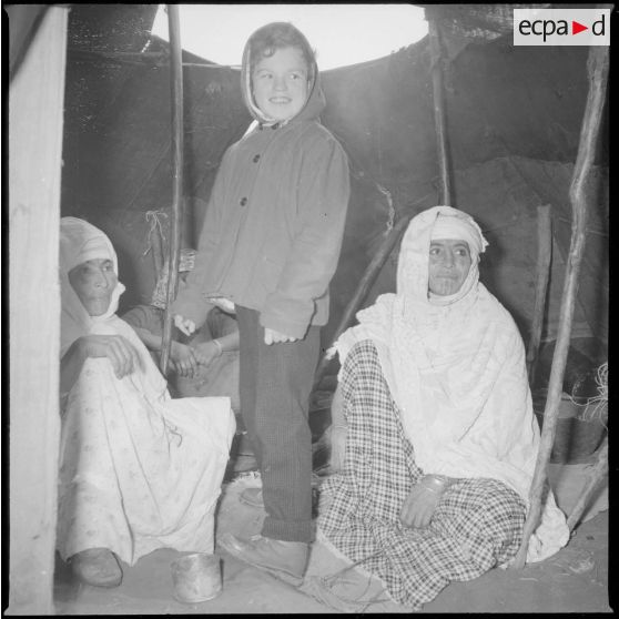 [Poste de Tamesna, région de Saïda. Enfant, venue de France, visitant des femmes et une jeune fille dans leur tente traditionnelle appelée khaïma.]