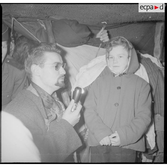 [Poste de Tamesna, région de Saïda. Journaliste de Radio Luxembourg interviewant une enfant venue de France.]