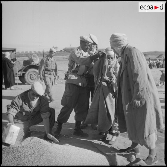 [Distribution de grain auprès d'une Algérienne par des soldats près de Saïda.]
