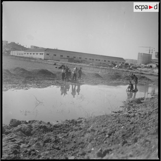 [Enfants algériens jouant dans une marre d'eau près de Nazareg-Flinois.]