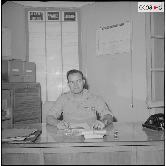 [Portrait d'un capitaine spahi du service presse (SP) du corps d'armée d'Oran (CAO) dans son bureau.]